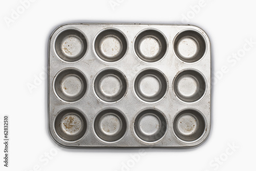 A well used, seasoned baking tray. Cookware.  A cupcake or muffin tin. photo