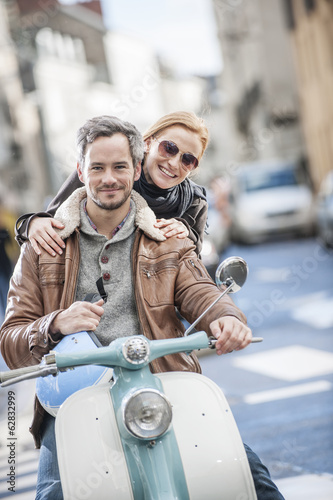 handsome couple riding a trendy scooter