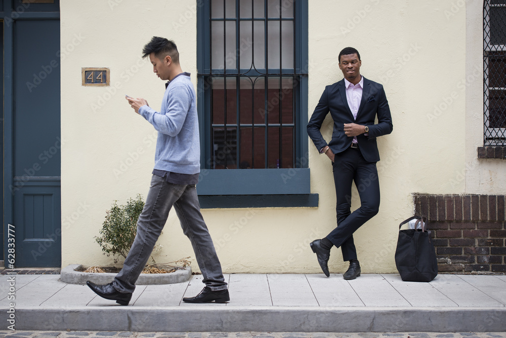 Young people outdoors on the city streets in springtime. A man leaning