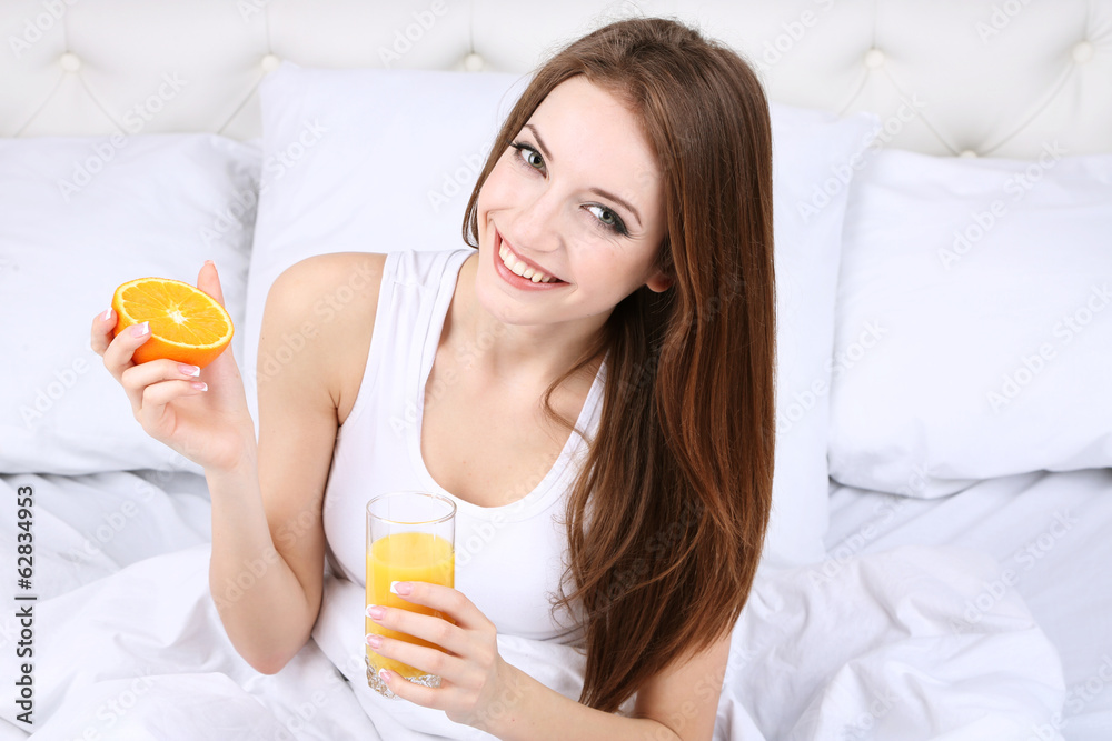 Young beautiful woman with orange juice in bed close-up Young beautiful woman with orange juice in bed close-up