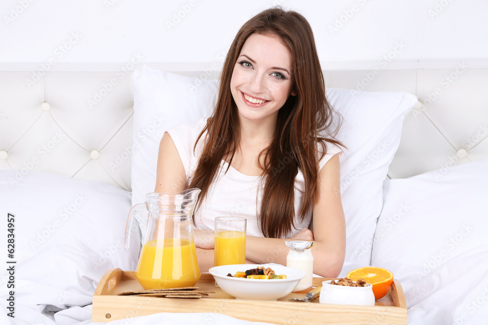 Young beautiful woman in bed with light breakfast Young beautiful woman in bed with light breakfast