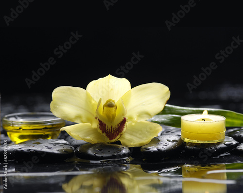 Pink orchid and black stones and candle