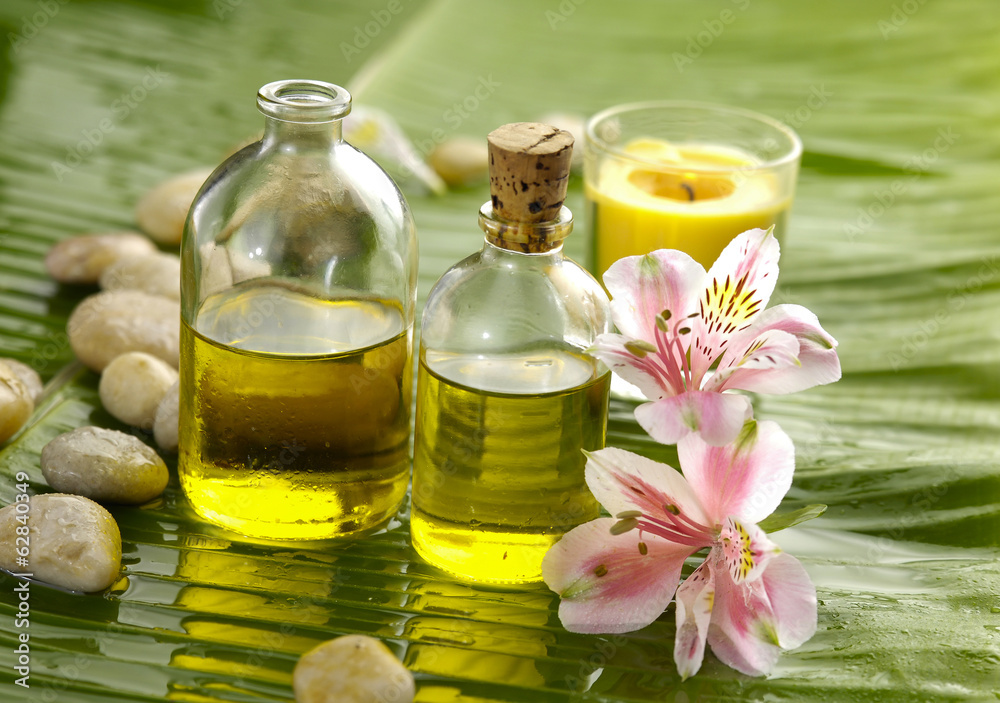 Health spa with massage oil and pink orchid on leaf Health spa with massage oil and pink orchid on leaf