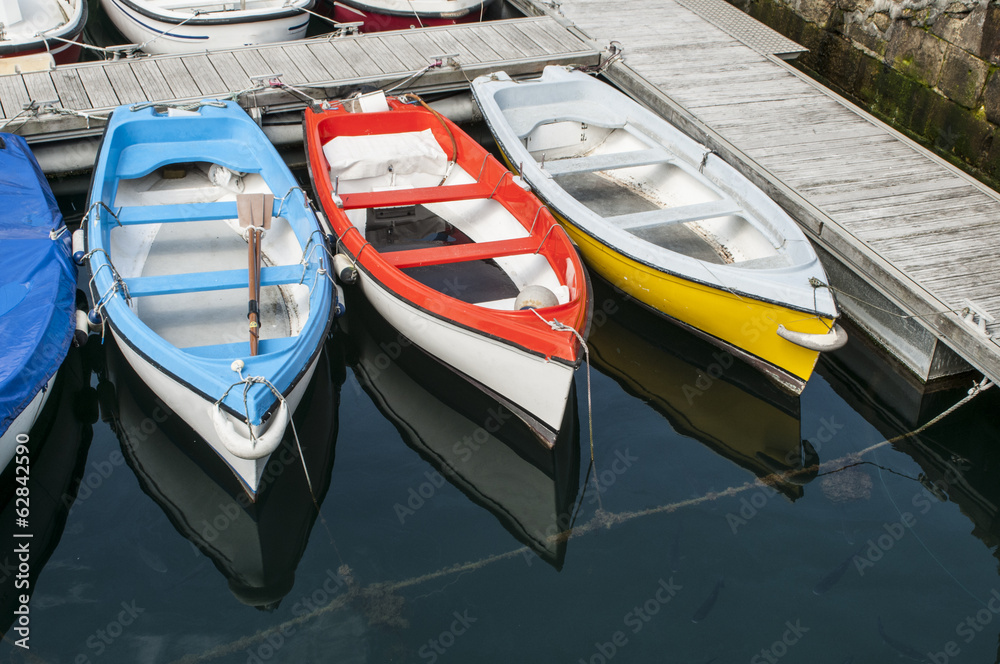 three boats reflected in the seawater