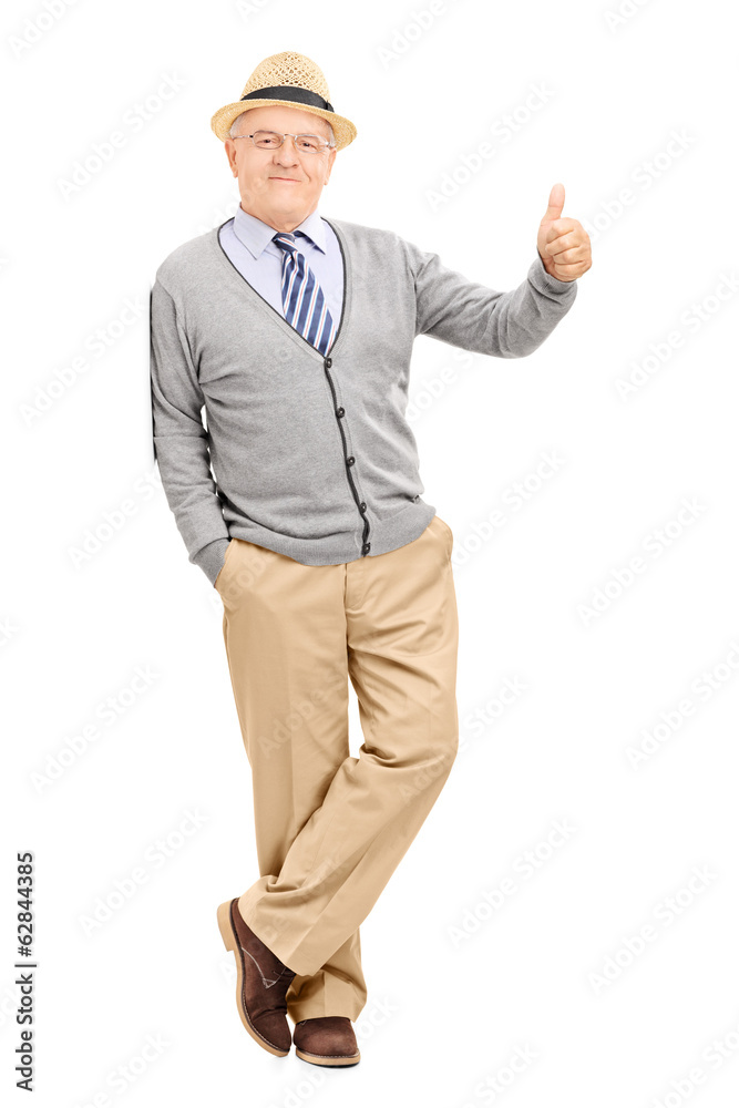 Man leaning against a wall and giving thumb up