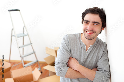 Portrait of a relaxed young man in his new flat photo