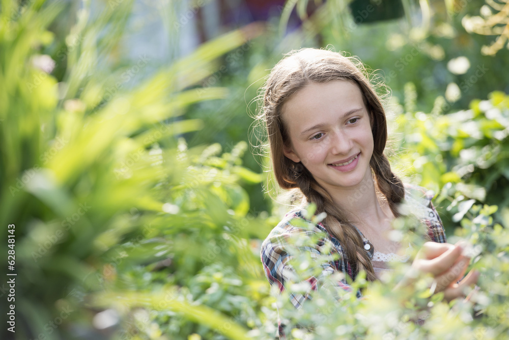 Summer on an organic farm. A young girl in a plant nursery full of flowers. Summer on an organic farm. A young girl in a plant nursery full of flowers.