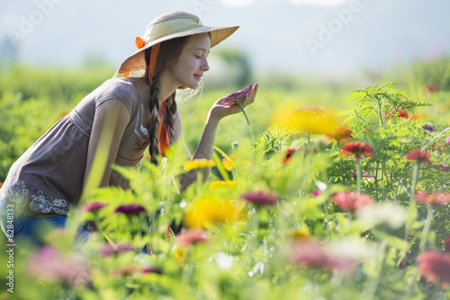 Summer on an organic farm. A young woman in a field of flowers. photo