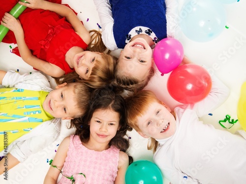 Croup of happy children lying in a circle