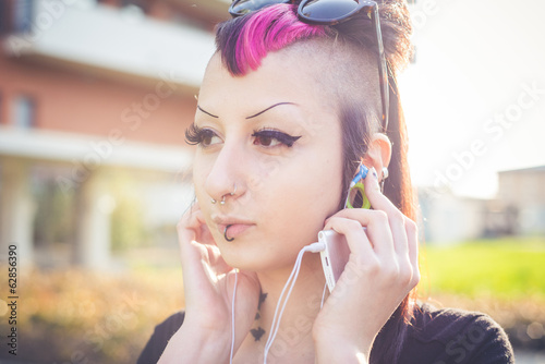 young beautiful punk dark girl listening music photo