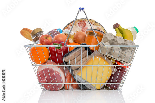 Shopping basket full of groceries isolated on white.