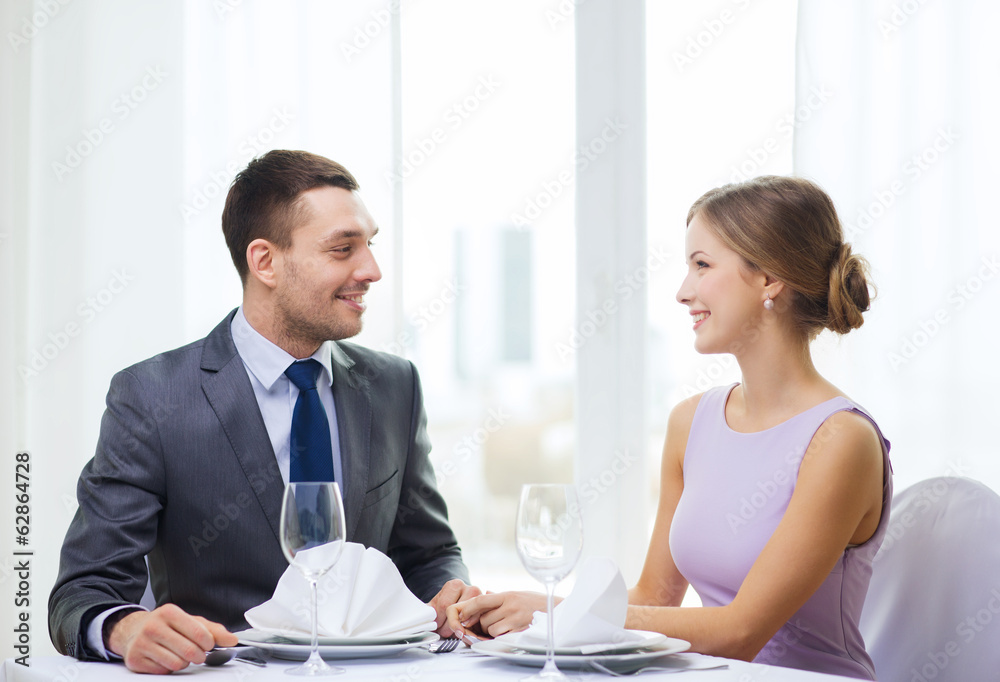 smiling couple looking at each other at restaurant smiling couple looking at each other at restaurant