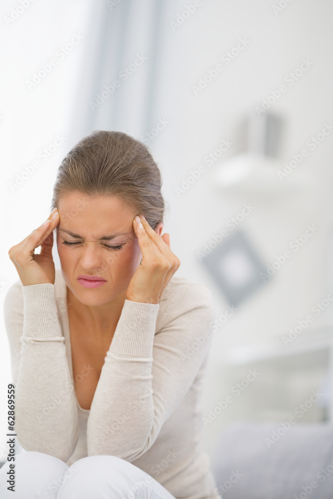 Young woman with head ache sitting on couch Young woman with head ache sitting on couch