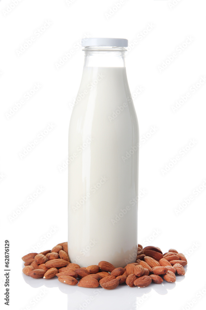 Almond milk in bottle with almonds, isolated on white Almond milk in bottle with almonds, isolated on white