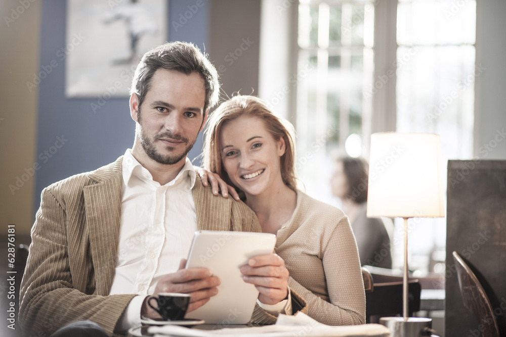 cheerful couple sitting in a cafe and using a digital tablet cheerful couple sitting in a cafe and using a digital tablet