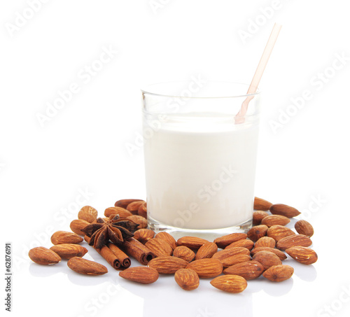 Almond milk in glass with almonds, isolated on white