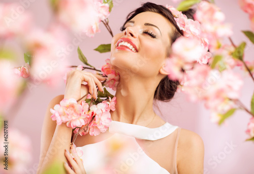 Pleased brunette woman among the flowers