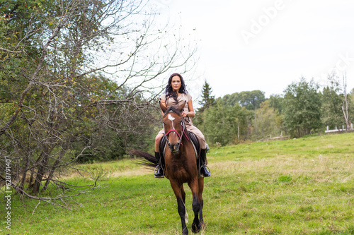 Elegant attractive woman riding a horse