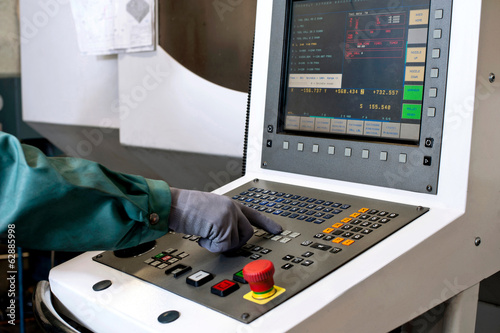 Quadro em tela Hand on the control panel of a computer numerical control progra