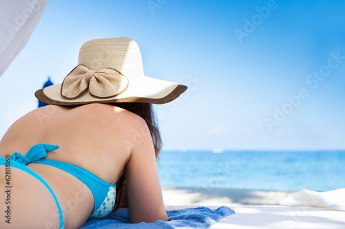 Woman In Sunhat Relaxing At Beach