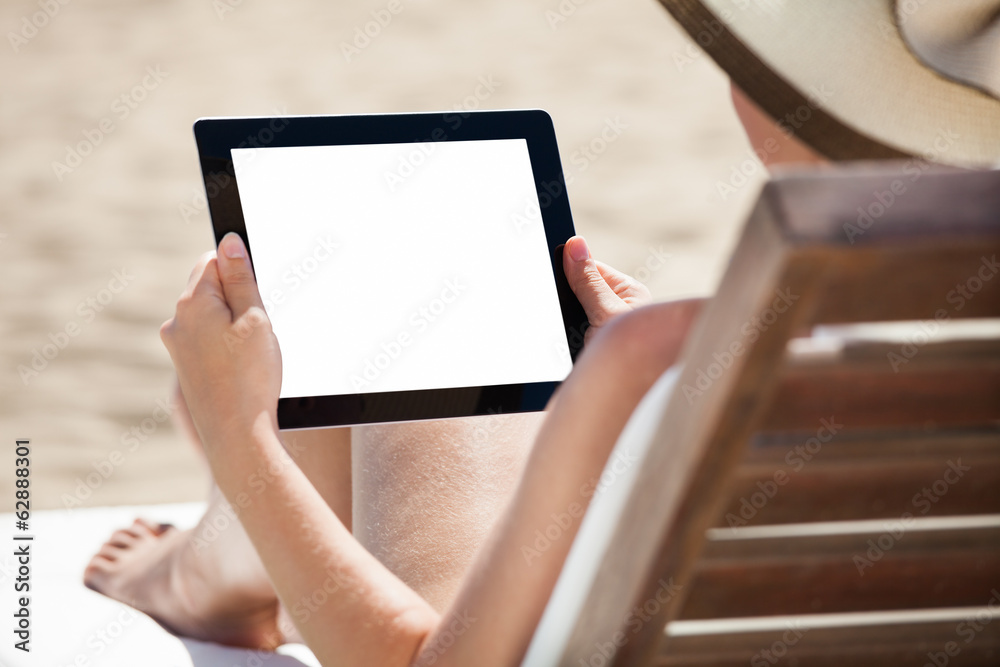 Woman Using Digital Tablet On Beach Chair
