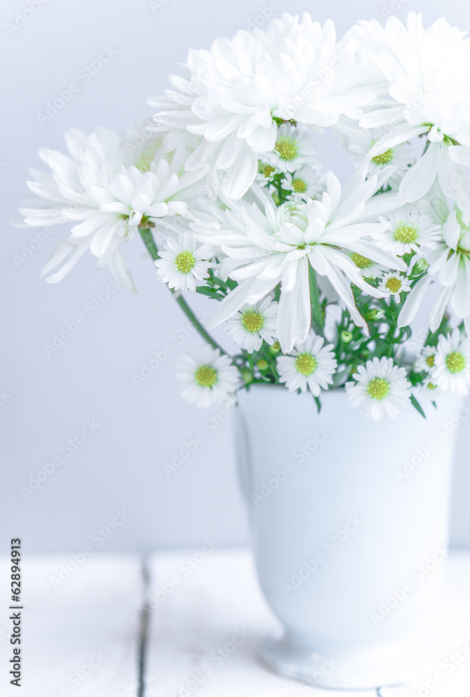 Daisies in white vase on wooden background Daisies in white vase on wooden background