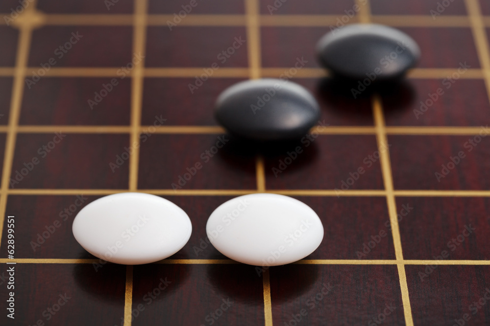 few stones during go game playing on goban few stones during go game playing on goban