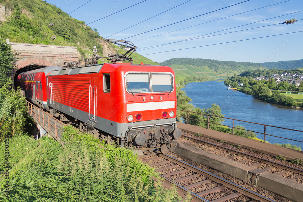 Naklejka premium Pociąg opuszczający tunel wzdłuż rzeki Mozeli w Niemczech