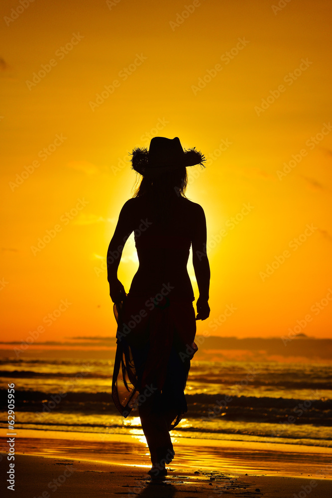 young woman silhouette on the beach in summer