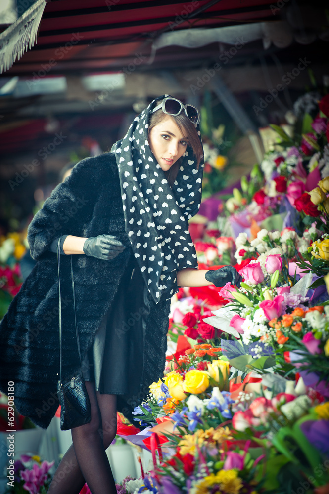 Beautiful brunette woman with gloves at florist shop
