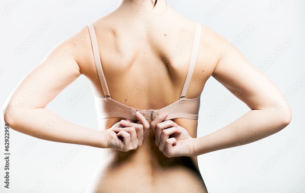 Obraz premium Wearing bra closeup, unhooking the clasp