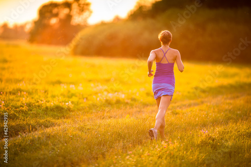 Young woman running outdoors on a lovely sunny summer evening