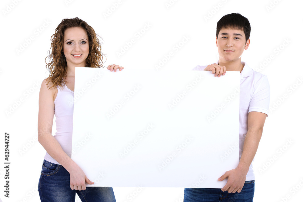 Two beautiful young people holding blank poster isolated Two beautiful young people holding blank poster isolated