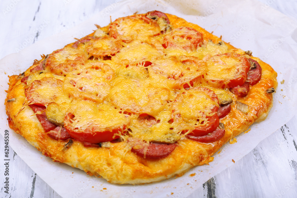 Homemade pizza on baking paper close up Homemade pizza on baking paper close up