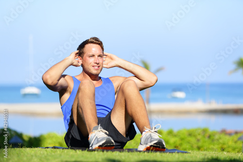 Man exercising sit-ups outside