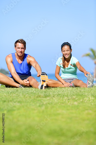 Fitness people - couple stretching exercises