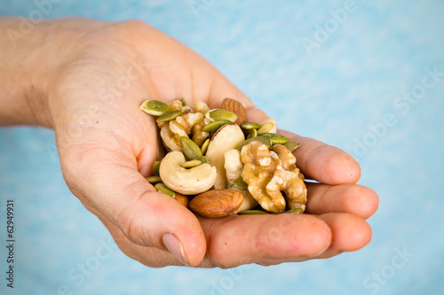 Hand holding a variety of nuts and seeds