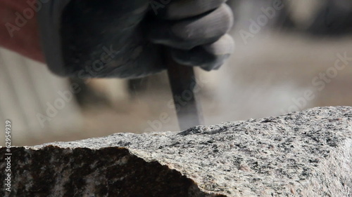 Stonemason making wedge-holes manually