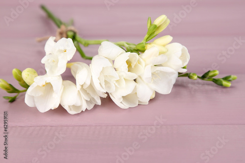 Beautiful freesias on wooden table