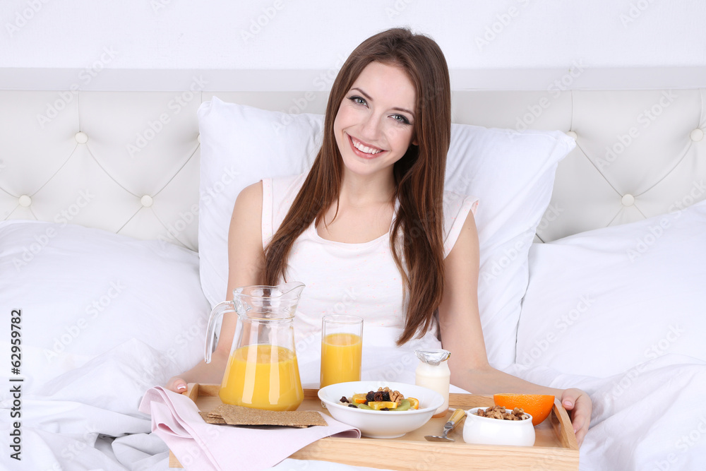 Young beautiful woman in bed with light breakfast Young beautiful woman in bed with light breakfast