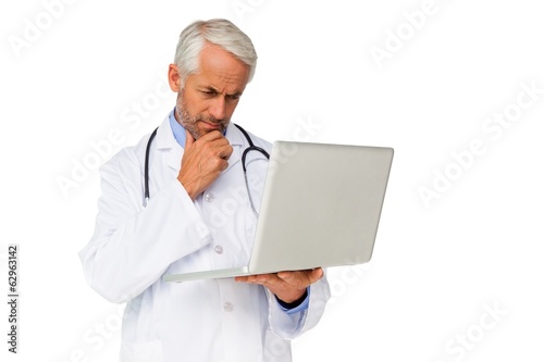 Concentrated male doctor using laptop