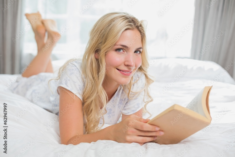 Beautiful young woman reading book in bed Beautiful young woman reading book in bed