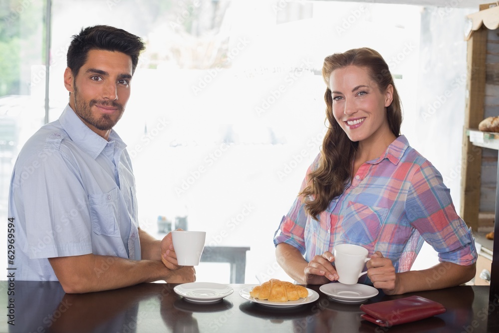 Smiling couple with coffee and croissant at coffee shop Smiling couple with coffee and croissant at coffee shop