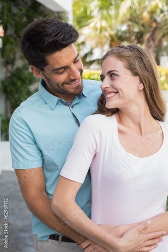 Loving man embracing woman from behind outdoors