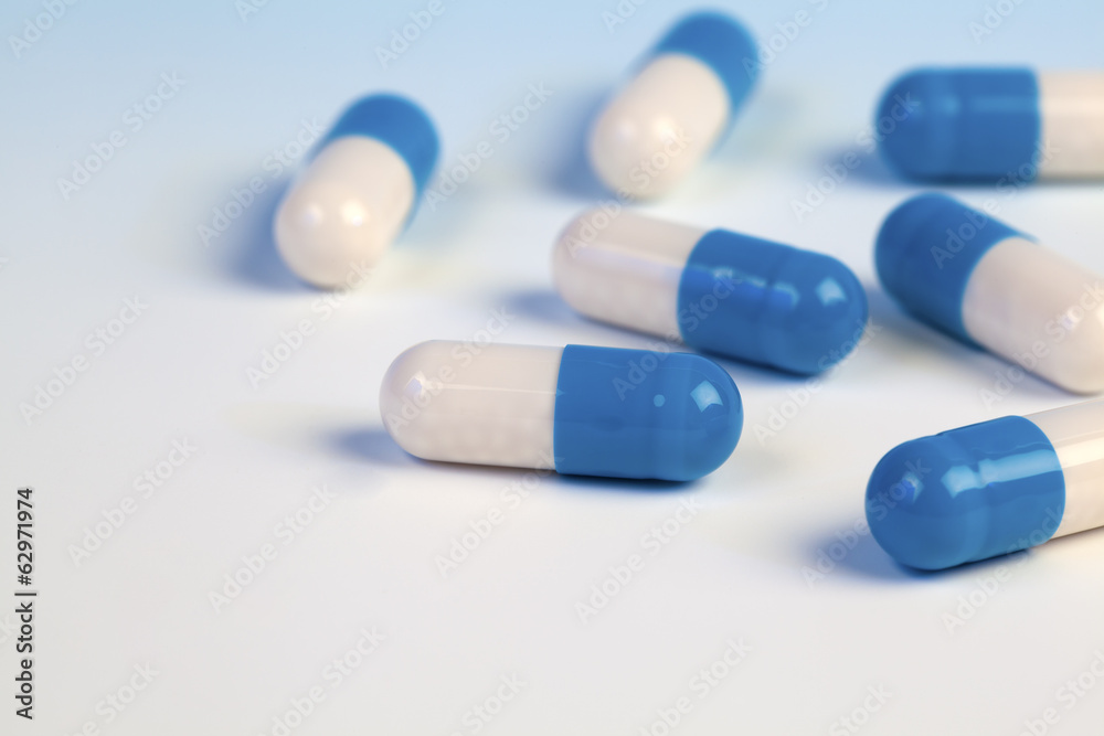 Colorful medical capsules on blue background. Colorful medical capsules on blue background.