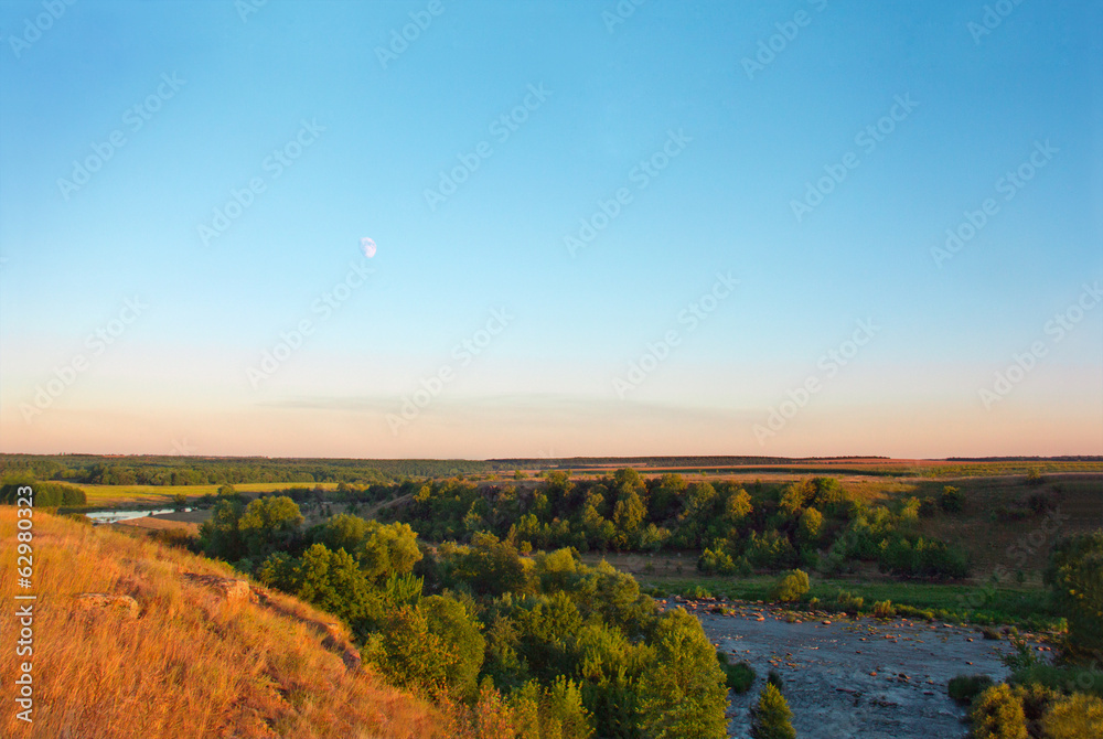 landscape consisting of the moon, sky, trees, field, river and a