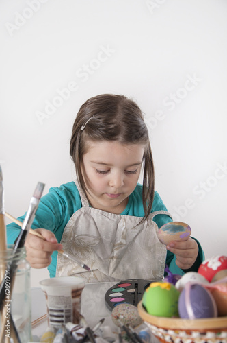 Cute little girl painting easter eggs photo