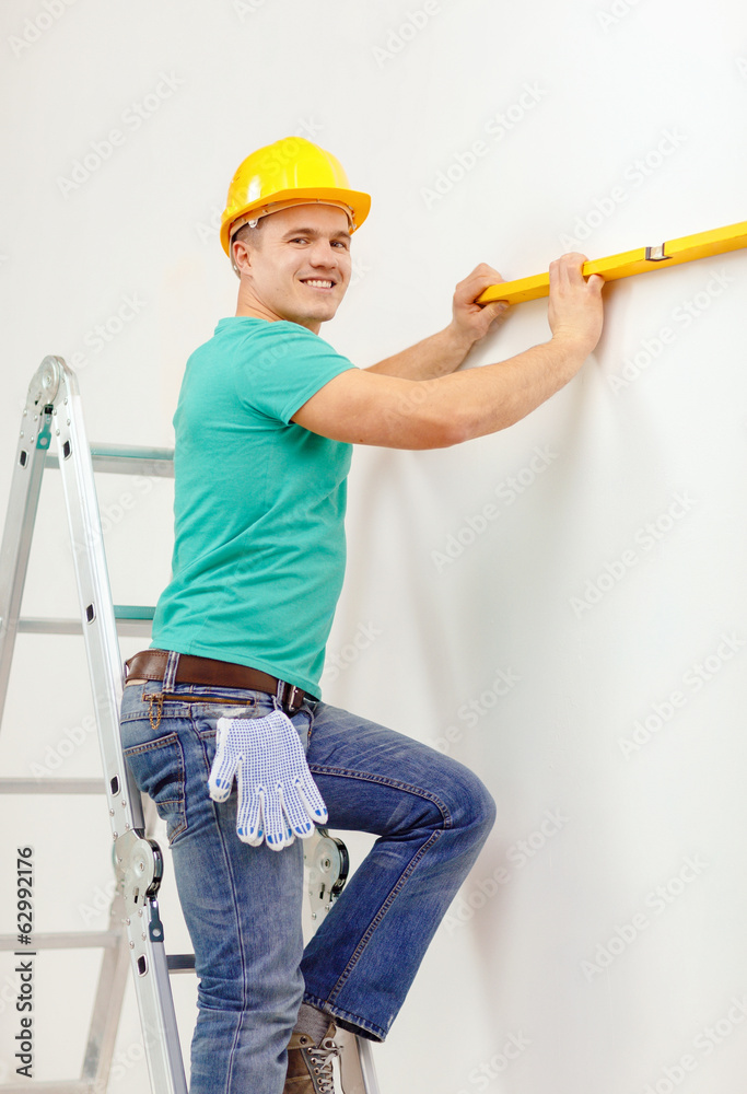 smiling man building using spirit level to measure smiling man building using spirit level to measure