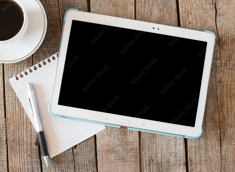 Empty tablet pc and a coffee and notebook with pen Empty tablet pc and a coffee and notebook with pen
