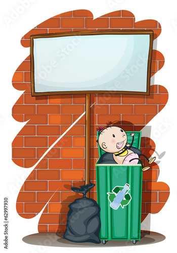 A baby inside the trashcan below an empty signboard